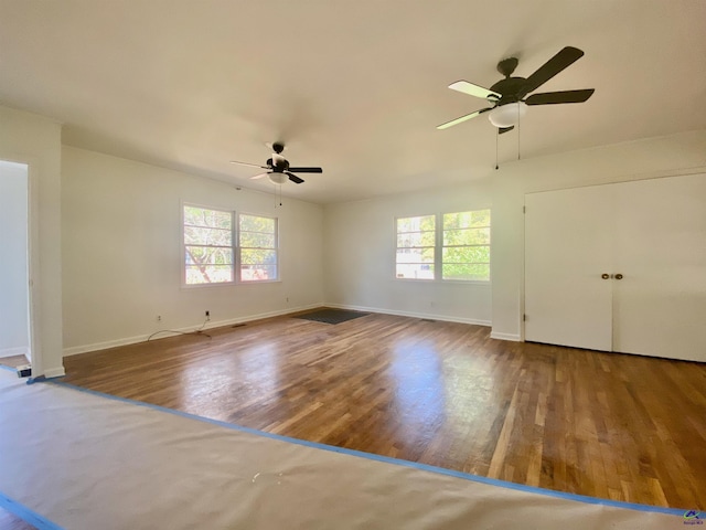 unfurnished living room featuring a ceiling fan, wood finished floors, and baseboards