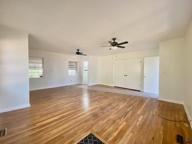 unfurnished living room with light wood-style flooring, baseboards, and ceiling fan