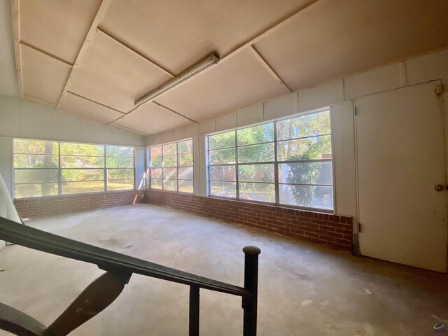 unfurnished sunroom featuring vaulted ceiling