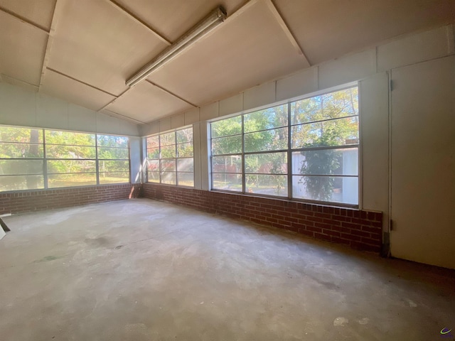 unfurnished sunroom featuring vaulted ceiling