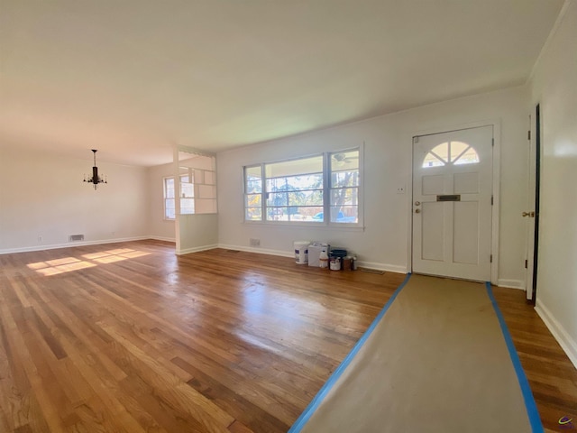 entrance foyer with visible vents, wood finished floors, and baseboards