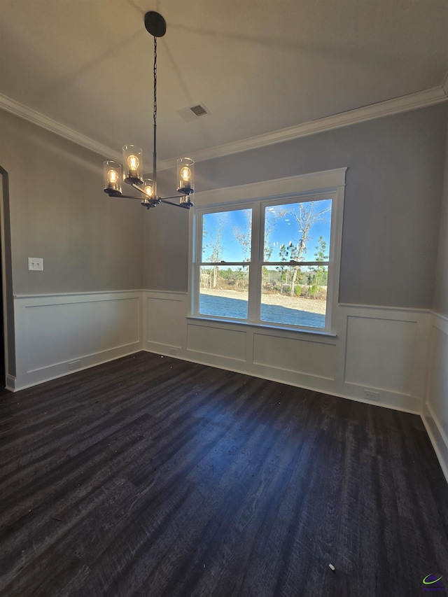 unfurnished dining area with dark hardwood / wood-style flooring, ornamental molding, and an inviting chandelier