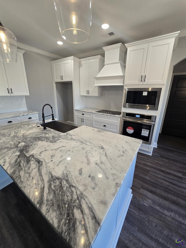 kitchen featuring white cabinets, premium range hood, and stainless steel appliances