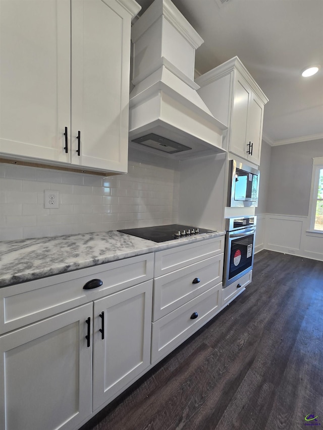 kitchen featuring white cabinetry, stainless steel appliances, light stone counters, dark hardwood / wood-style floors, and custom range hood