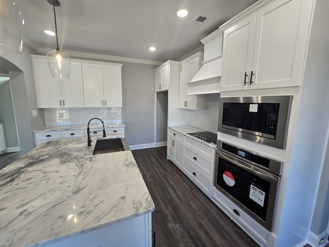 kitchen with white cabinetry, sink, backsplash, decorative light fixtures, and appliances with stainless steel finishes