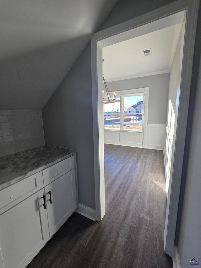 interior space featuring an inviting chandelier, hardwood / wood-style flooring, and vaulted ceiling