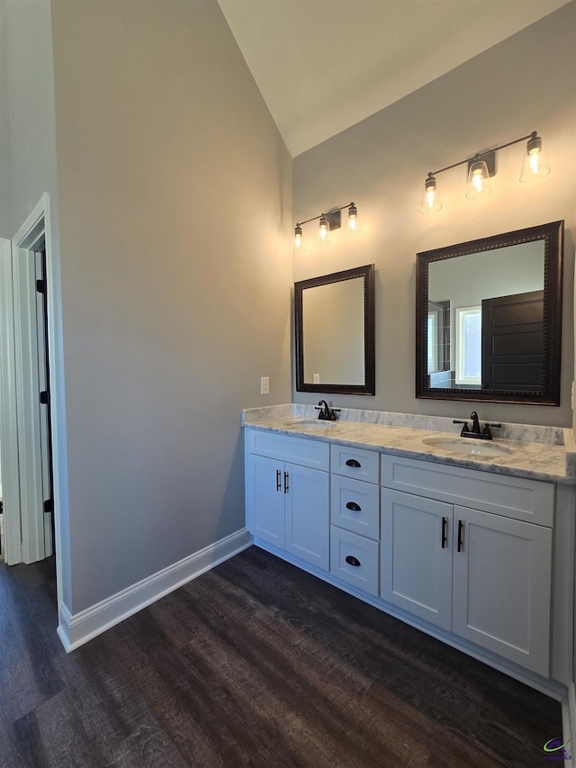 bathroom featuring hardwood / wood-style floors, vanity, and lofted ceiling