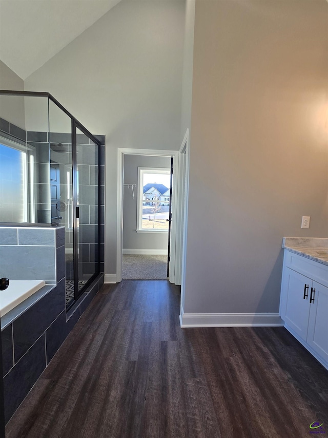 bathroom with hardwood / wood-style floors, vanity, separate shower and tub, and lofted ceiling