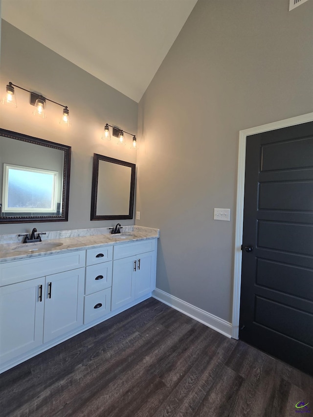 bathroom featuring vanity, wood-type flooring, and vaulted ceiling