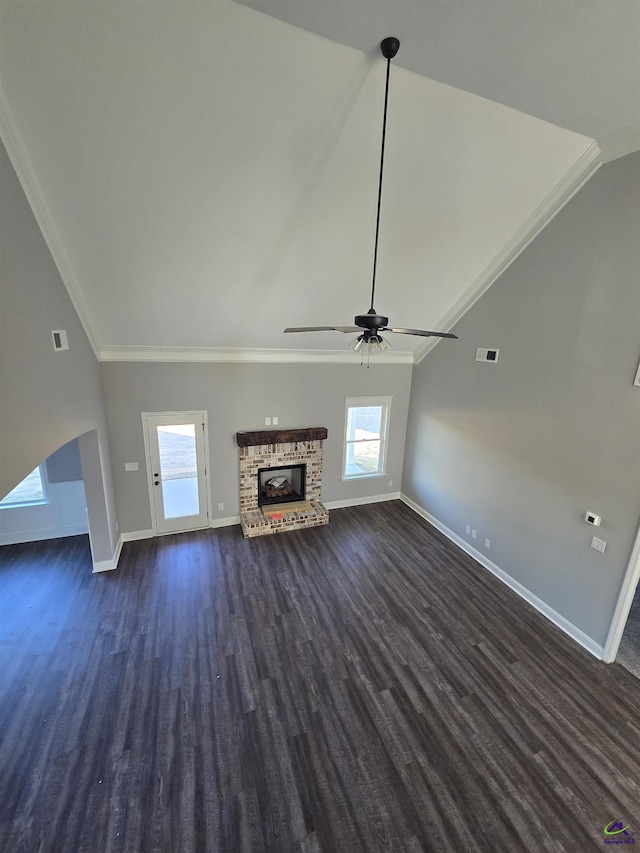 unfurnished living room featuring plenty of natural light, ornamental molding, and dark wood-type flooring