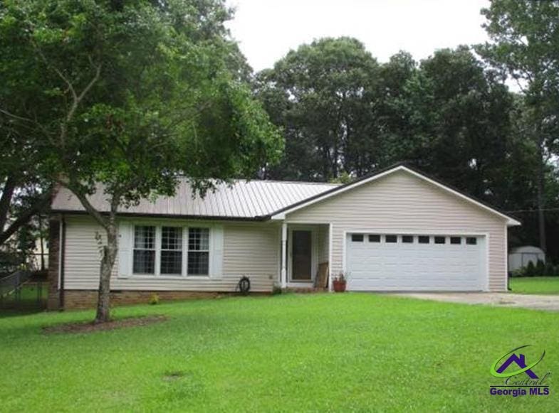 ranch-style home with a garage and a front yard