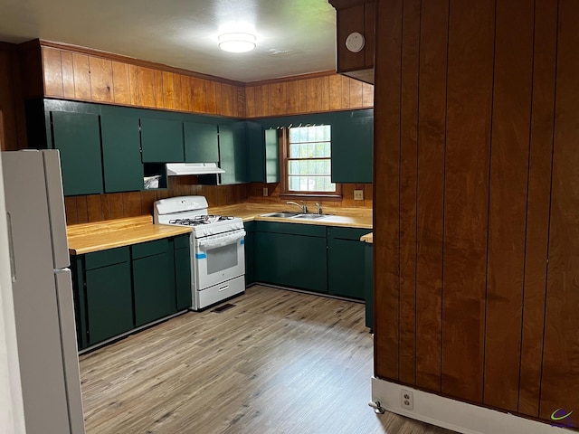 kitchen with light hardwood / wood-style floors, white appliances, and sink