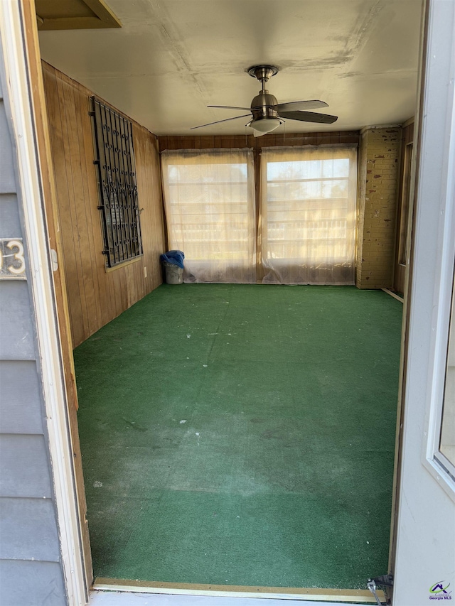 unfurnished sunroom with ceiling fan