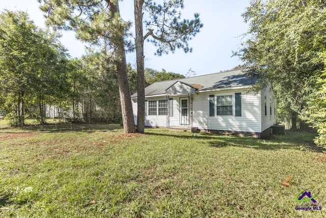 ranch-style house featuring central AC unit and a front lawn