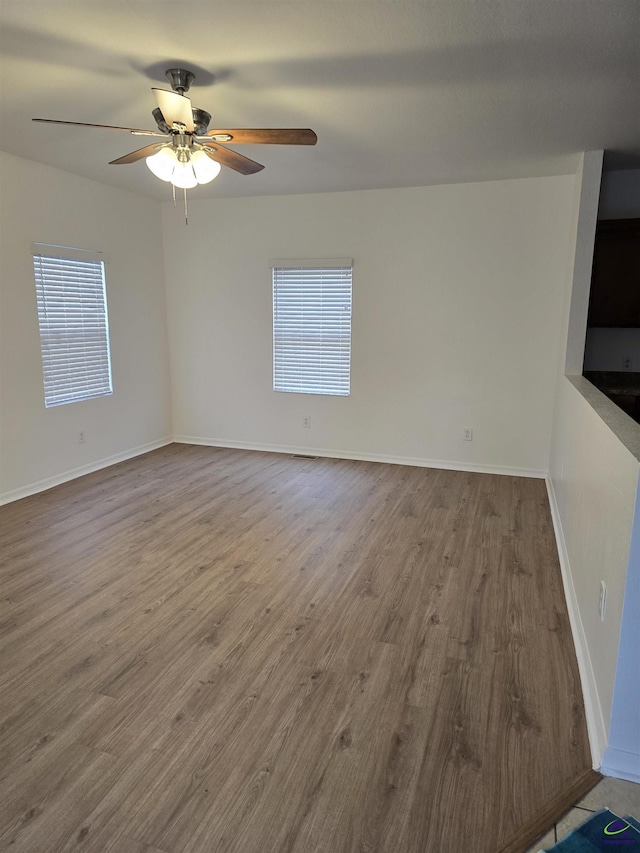 unfurnished room with hardwood / wood-style floors, a wealth of natural light, and ceiling fan