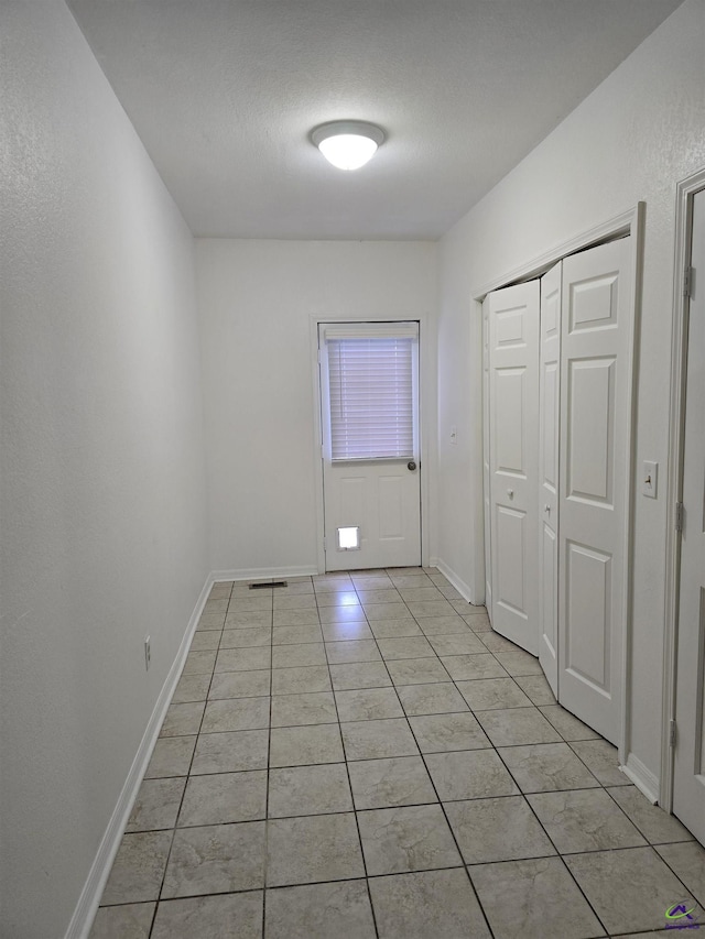 interior space with light tile patterned floors and a textured ceiling