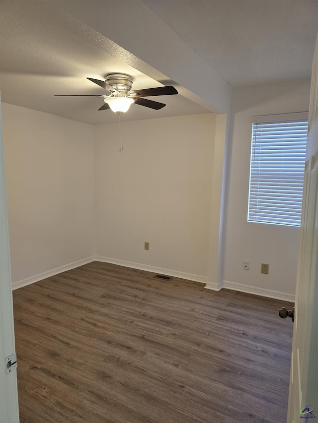 spare room featuring dark hardwood / wood-style flooring and ceiling fan