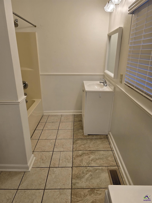 bathroom featuring tile patterned flooring, vanity, and bathtub / shower combination