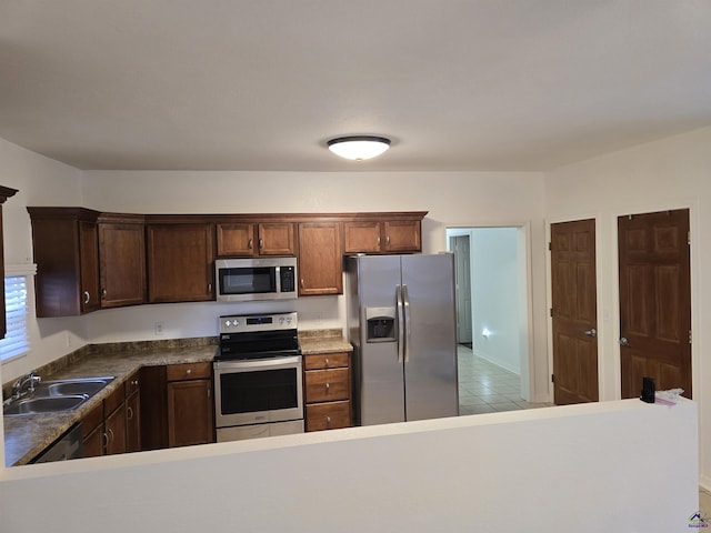 kitchen featuring light tile patterned floors, sink, and appliances with stainless steel finishes