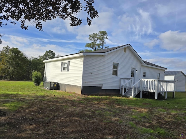 back of property featuring a yard, a deck, and cooling unit