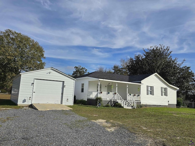 manufactured / mobile home featuring a garage, covered porch, an outbuilding, and a front yard