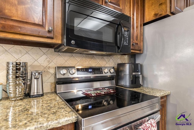 kitchen with tasteful backsplash, light stone countertops, and stainless steel appliances