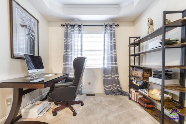 carpeted home office featuring a tray ceiling and ornamental molding