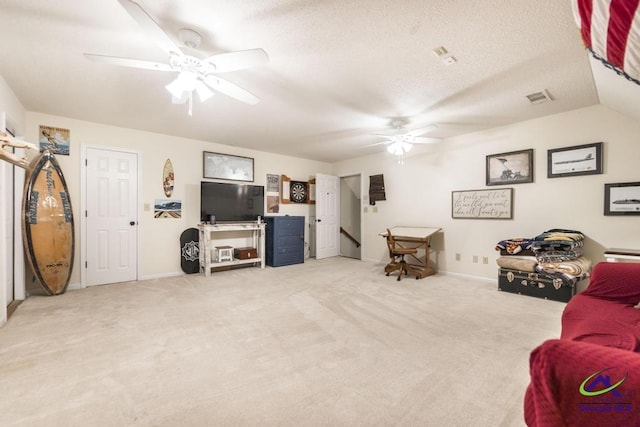 living room with ceiling fan, light colored carpet, lofted ceiling, and a textured ceiling