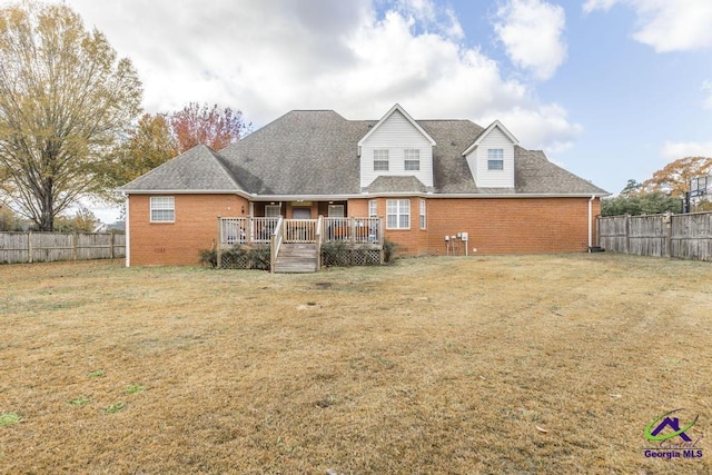 back of property featuring a deck and a lawn