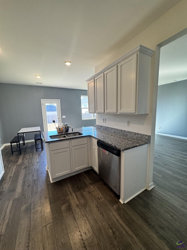 kitchen featuring dishwasher, sink, dark wood-type flooring, kitchen peninsula, and white cabinets