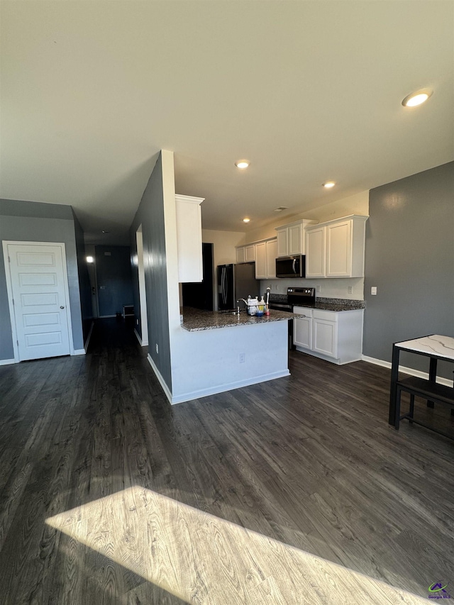 kitchen featuring kitchen peninsula, dark hardwood / wood-style flooring, white cabinetry, and black appliances