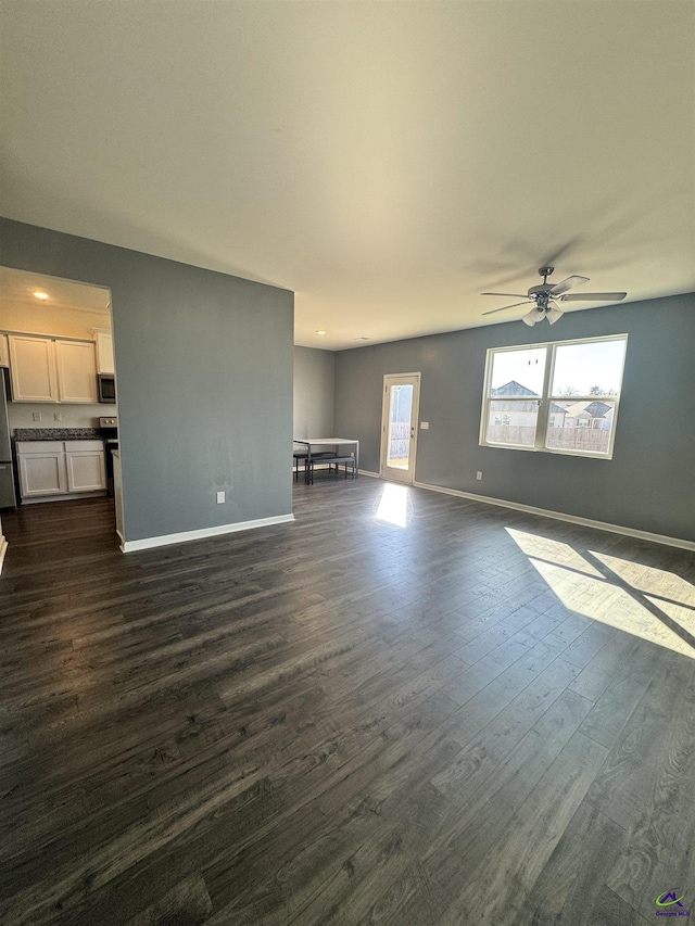 unfurnished living room with dark hardwood / wood-style floors and ceiling fan