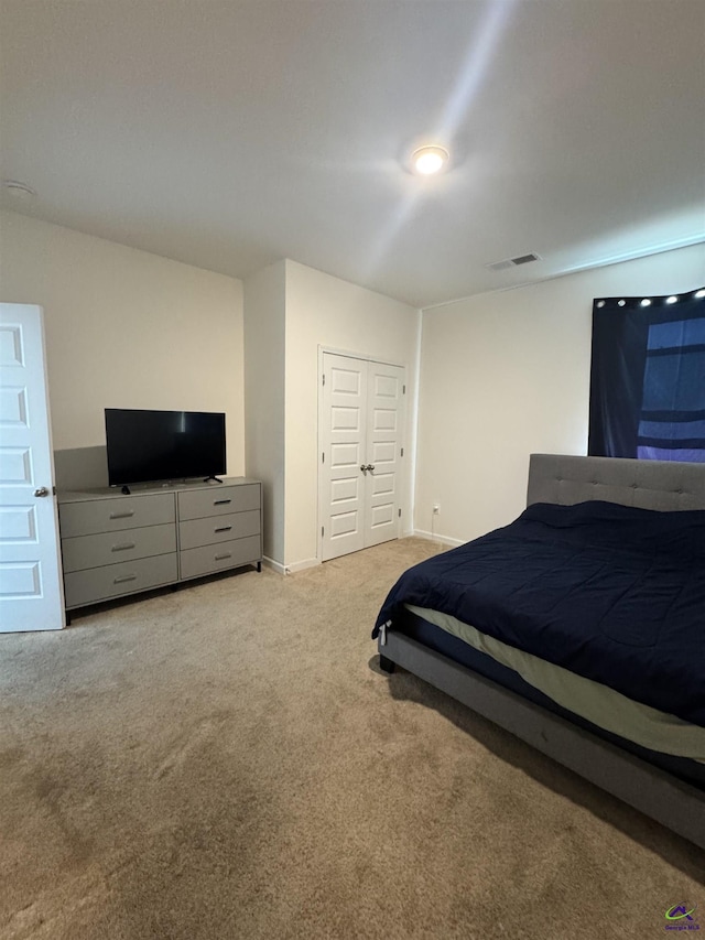 bedroom featuring a closet and light colored carpet