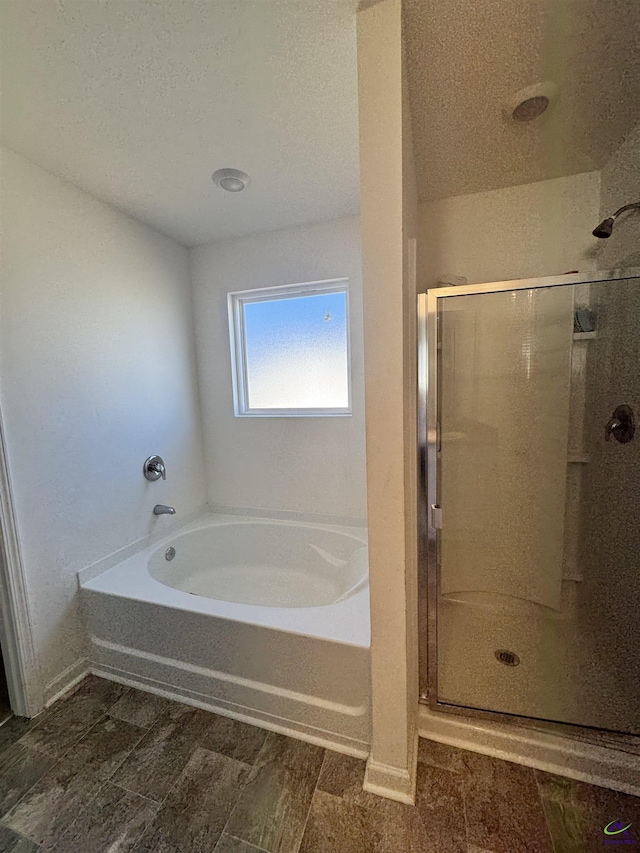 bathroom with plus walk in shower and a textured ceiling