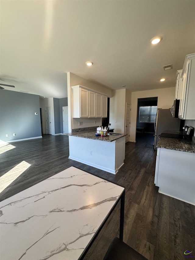 kitchen featuring dark stone countertops, ceiling fan, white cabinets, and dark hardwood / wood-style floors