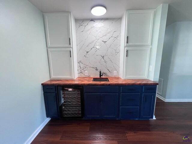 bar with blue cabinets, dark wood-type flooring, white cabinets, butcher block countertops, and wine cooler