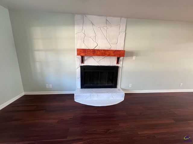 unfurnished living room featuring a fireplace and dark hardwood / wood-style flooring