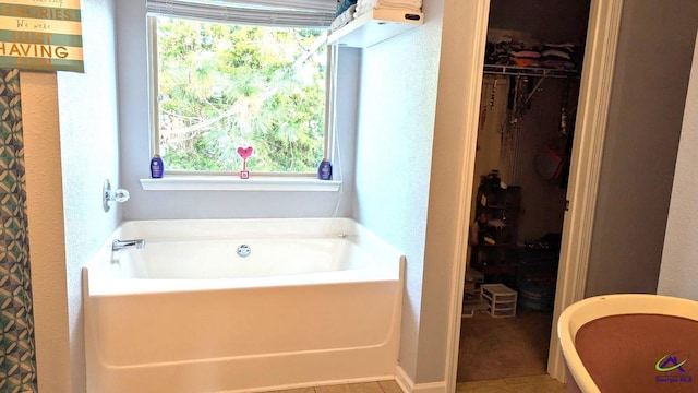 bathroom with a bathing tub and tile patterned flooring