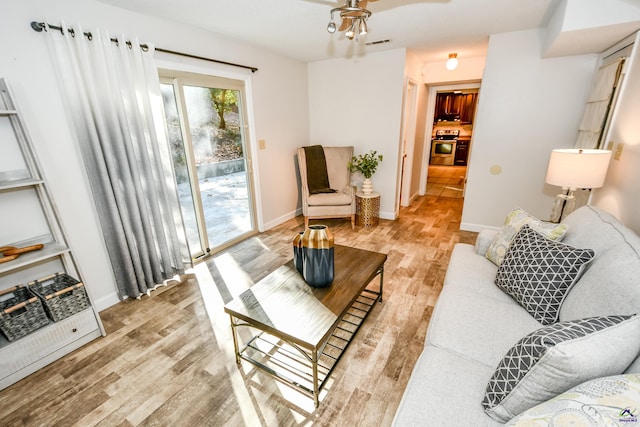 living room featuring ceiling fan and light hardwood / wood-style flooring