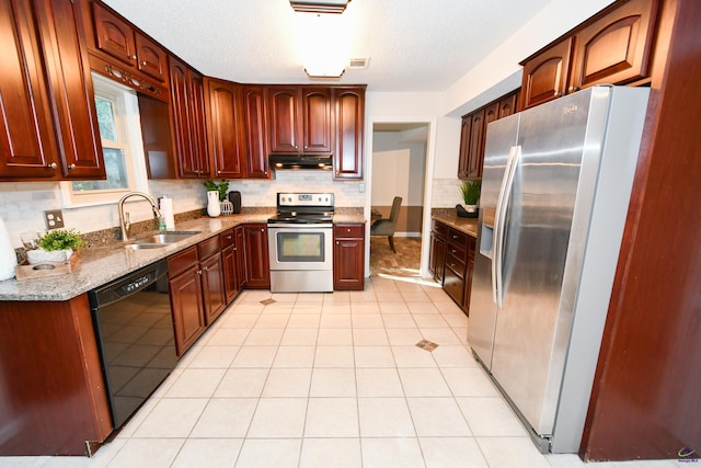 kitchen with sink, light stone counters, a textured ceiling, light tile patterned floors, and appliances with stainless steel finishes