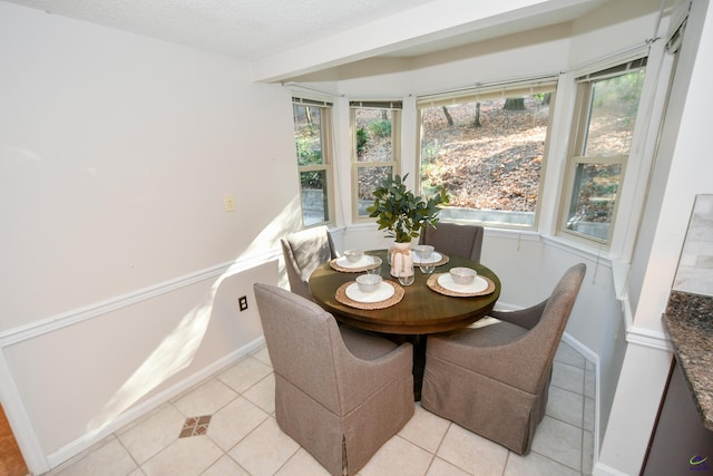 dining space featuring light tile patterned floors and a textured ceiling