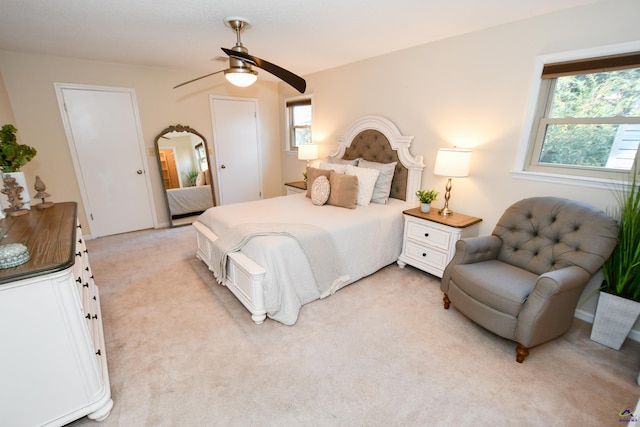 carpeted bedroom featuring ceiling fan and multiple windows