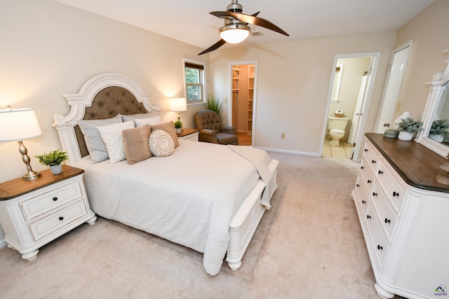 carpeted bedroom with ceiling fan, a walk in closet, connected bathroom, and a closet