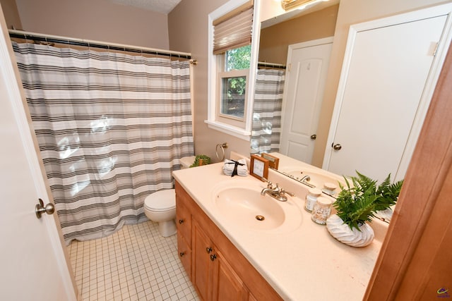 bathroom with tile patterned flooring, vanity, and toilet