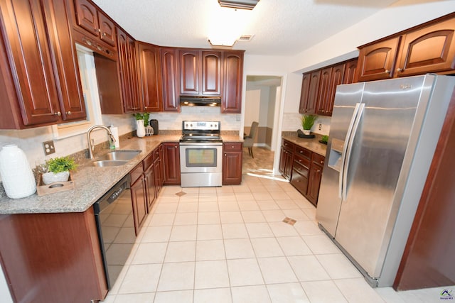 kitchen with light stone countertops, sink, stainless steel appliances, backsplash, and a textured ceiling