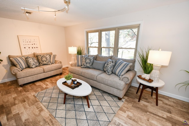 living room with wood-type flooring and a textured ceiling