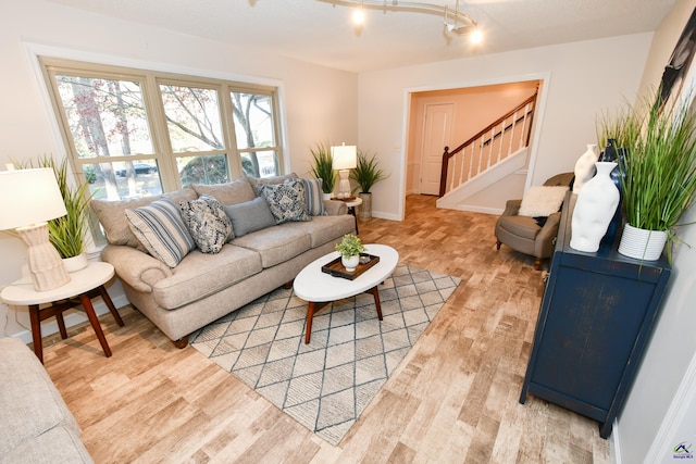 living room with light wood-type flooring and rail lighting