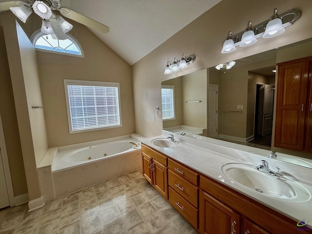 bathroom featuring ceiling fan, a washtub, a textured ceiling, lofted ceiling, and vanity