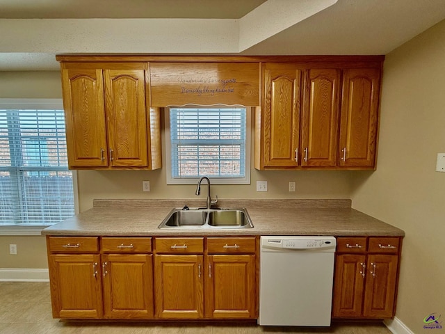 kitchen featuring white dishwasher, sink, and a wealth of natural light