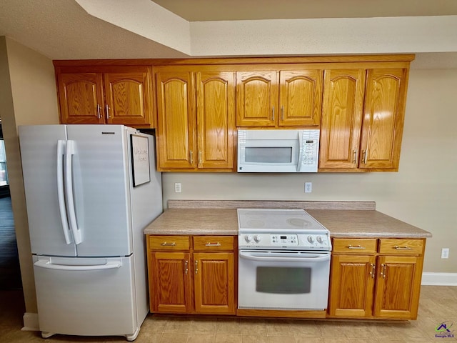 kitchen with light tile patterned flooring and white appliances